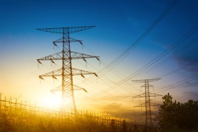 Integrated Operation Project of East Karaj Power Distribution Management | Sunset behind high voltage electricity pylons