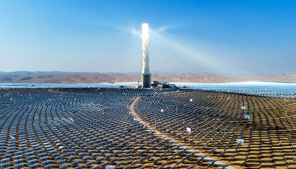 Central receiver solar power plant with a field of heliostats concentrating intense sunlight onto the top of the tower.